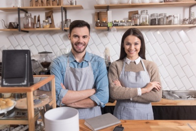Smiling couple crossing hands while standing behind bar. Why You Should Plan For A Business Succession In Arizona